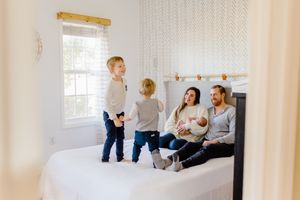 family on pattern barn bed with new baby
