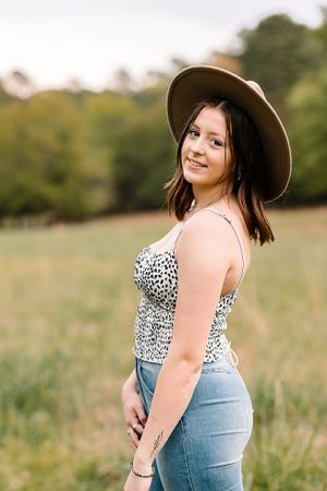 senior girl session in field with a fedora